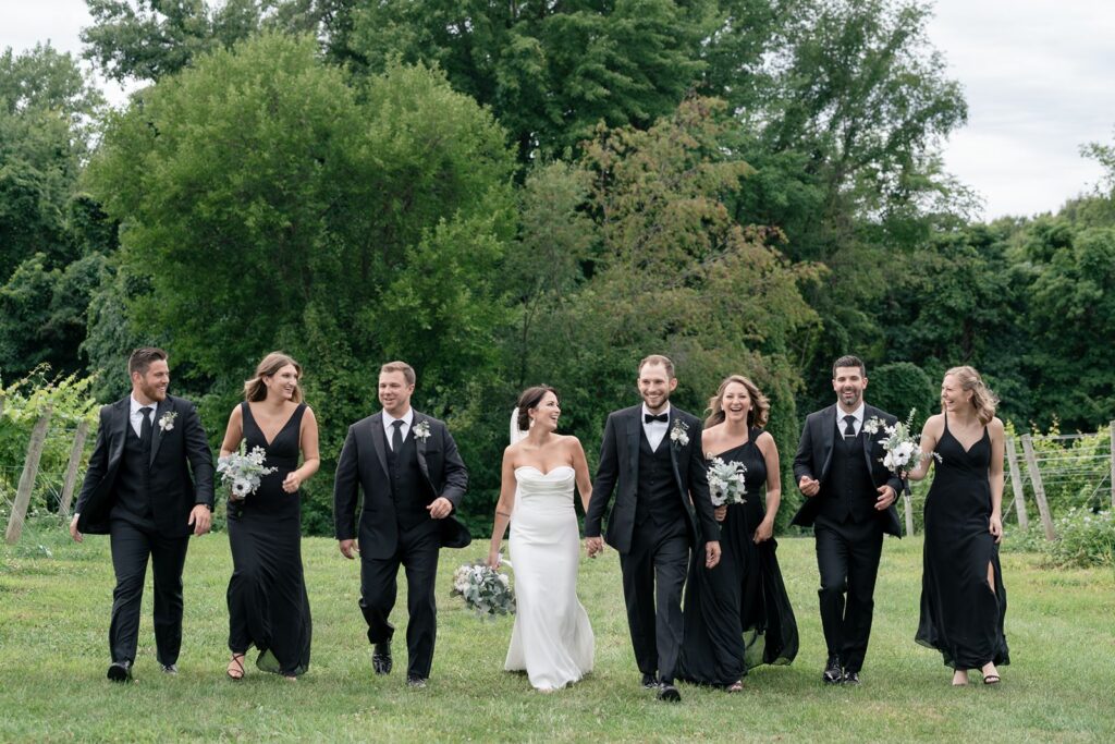 Tabor hill weddings bride and groom with wedding party in vineyard wearing black and white