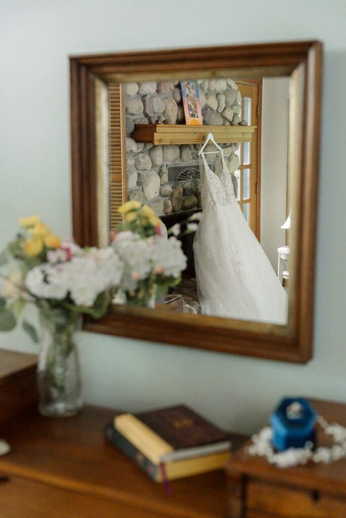 Bridal gown hanging from the mantle in a reflection