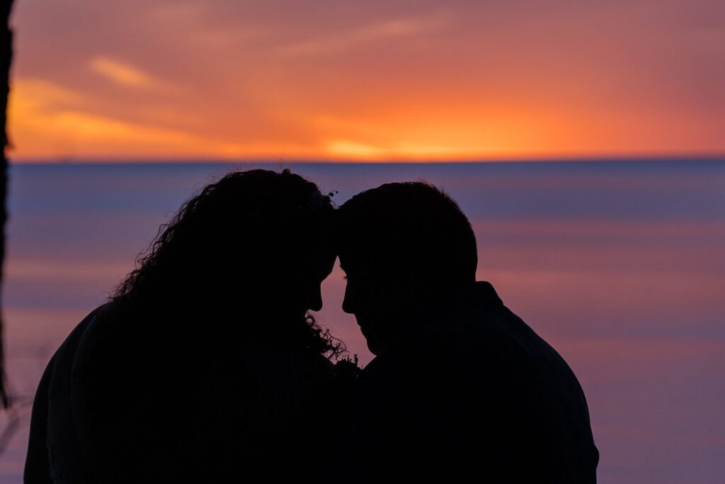 sunset two brides silhouette lake michigan elopement